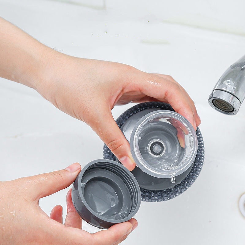 Hand washing a gray water bottle lid and cup under a kitchen faucet