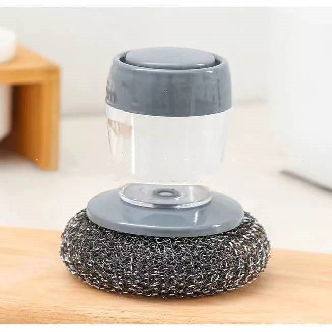 Kitchen soap dispenser scrubber with metal sponge for dish cleaning on wooden surface